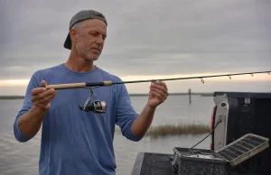 Rod Guide Materials and Why Most Anglers Overpay Angler sighting down a spinning rod to inspect the guide train at the tailgate after a morning tide