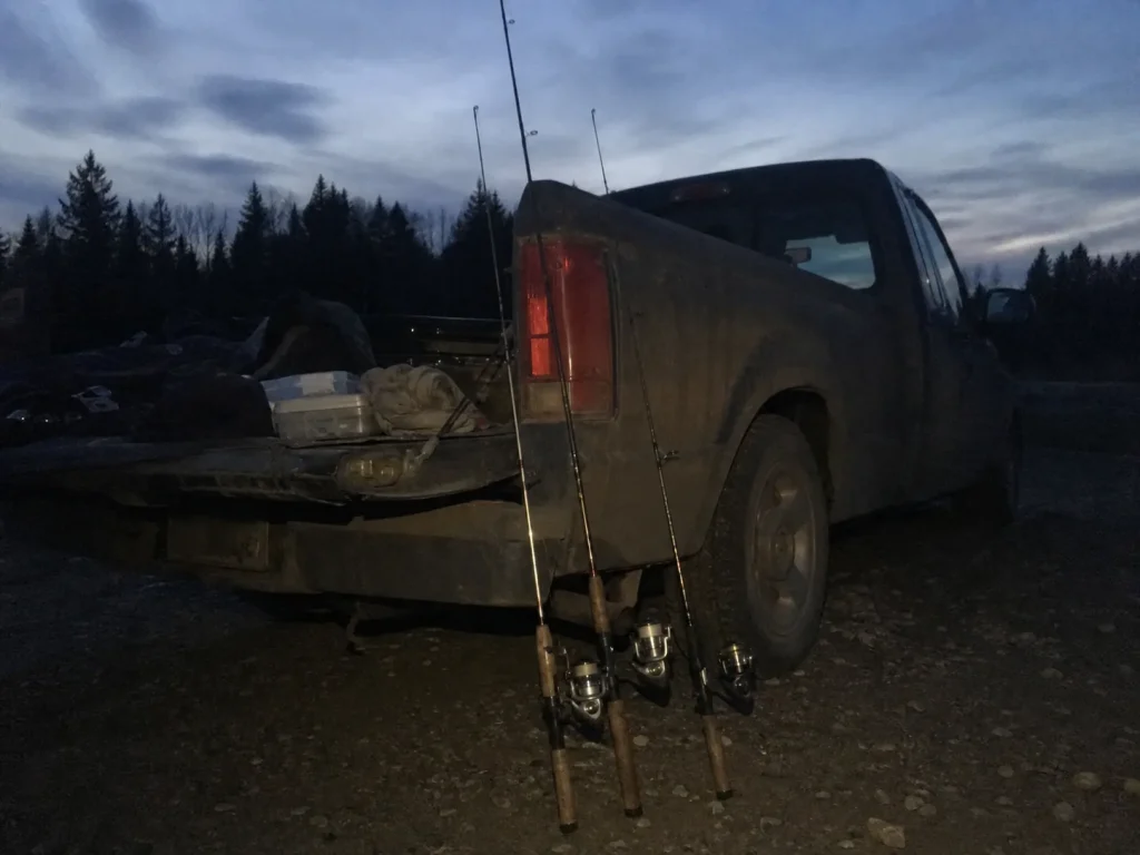 Three rods of different lengths leaning against a truck at dusk, the honest picks by rod length tier