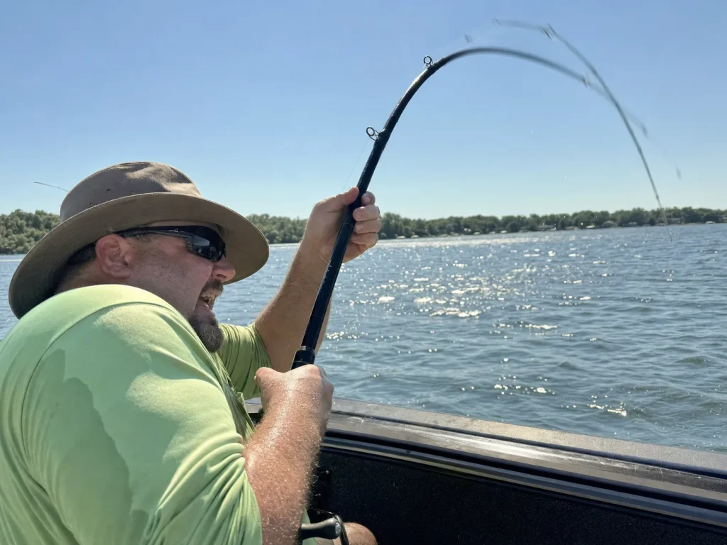 Angler high-sticking a fishing rod at a steep angle while fighting a fish, a warranty-void risk