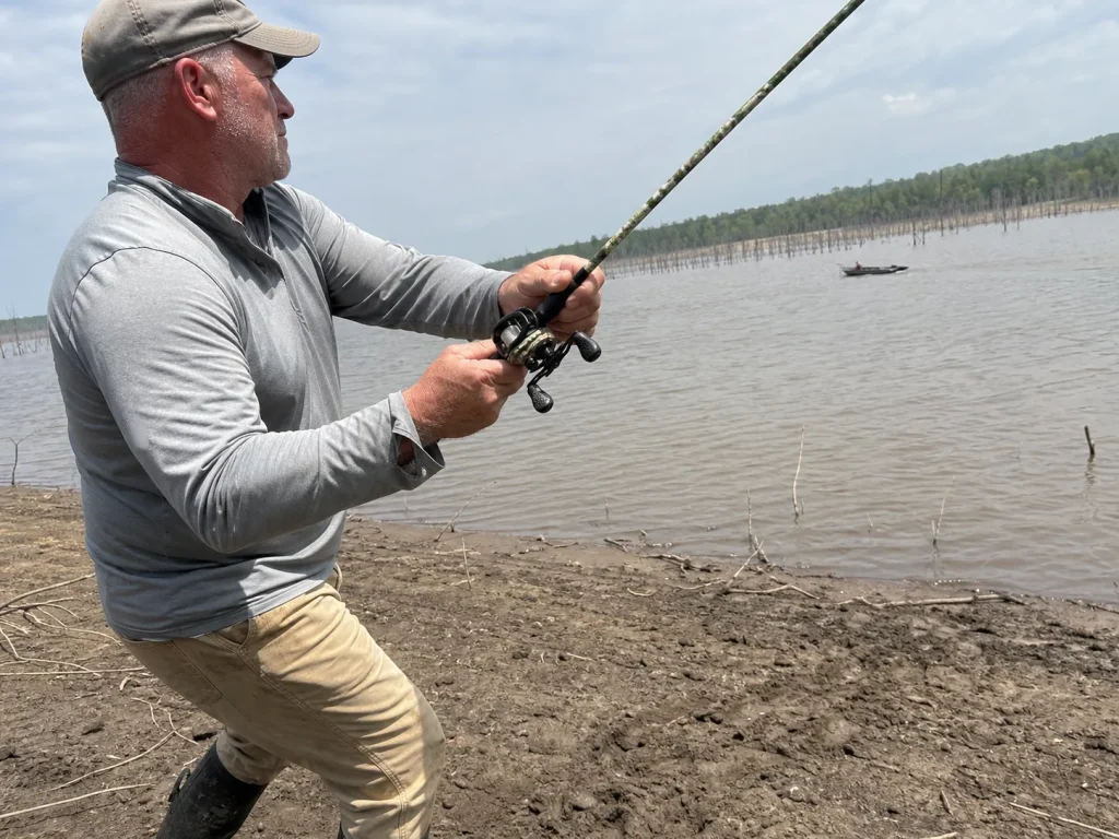Angler mid-cast on a lake bank with a baitcast combo, showing what rod balance costs