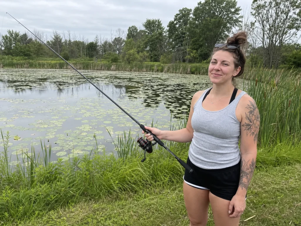Beginner angler fishing a 7-foot spinning combo from a pond bank, the all-around rod length default