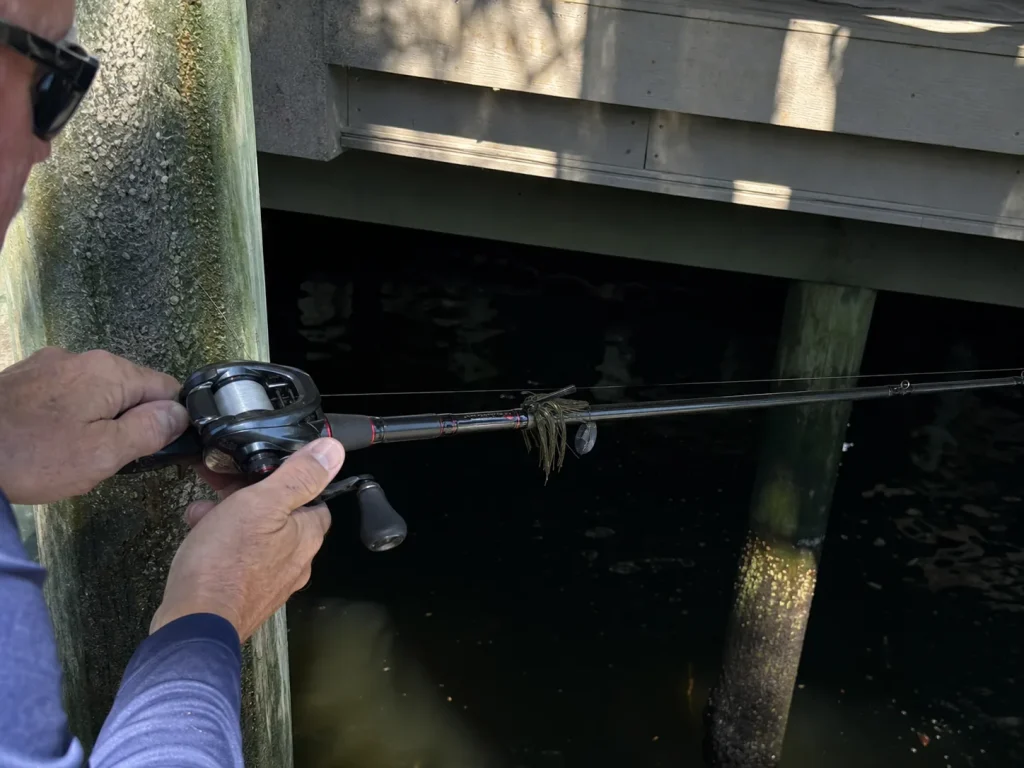 Angler flipping a jig under a dock with a 7-foot medium-heavy rod, matching rod length to technique