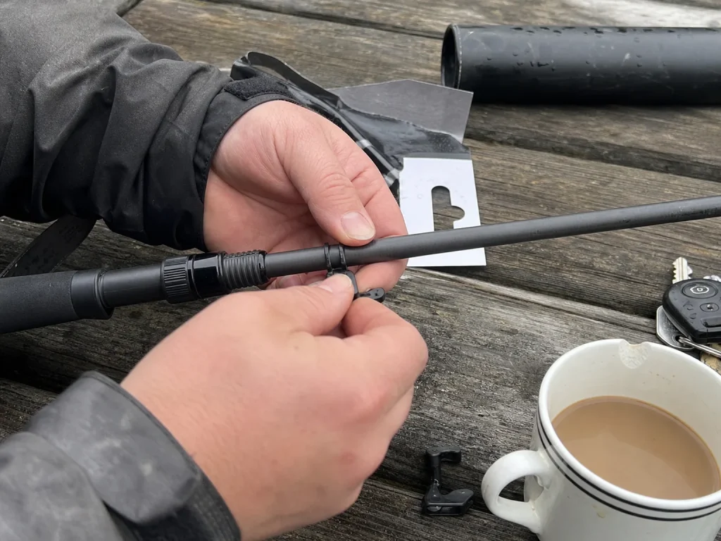 Hands fitting a manufactured clip-on hook keeper onto a rod blank that came with no factory keeper
