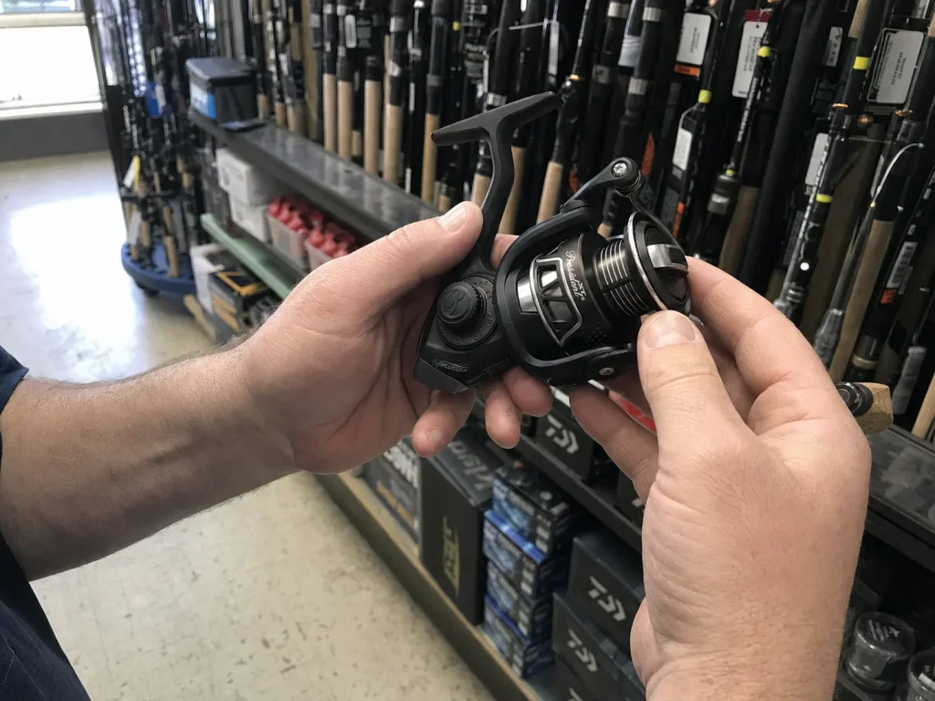 Hand holding a 30 size spinning reel against rod options while matching reel size to rod