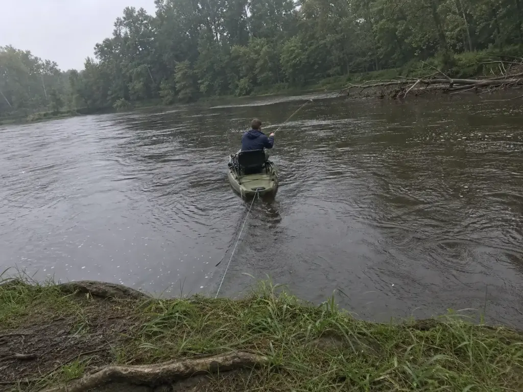 Anchored fishing kayak weathervaned bow-first into current instead of sitting broadside