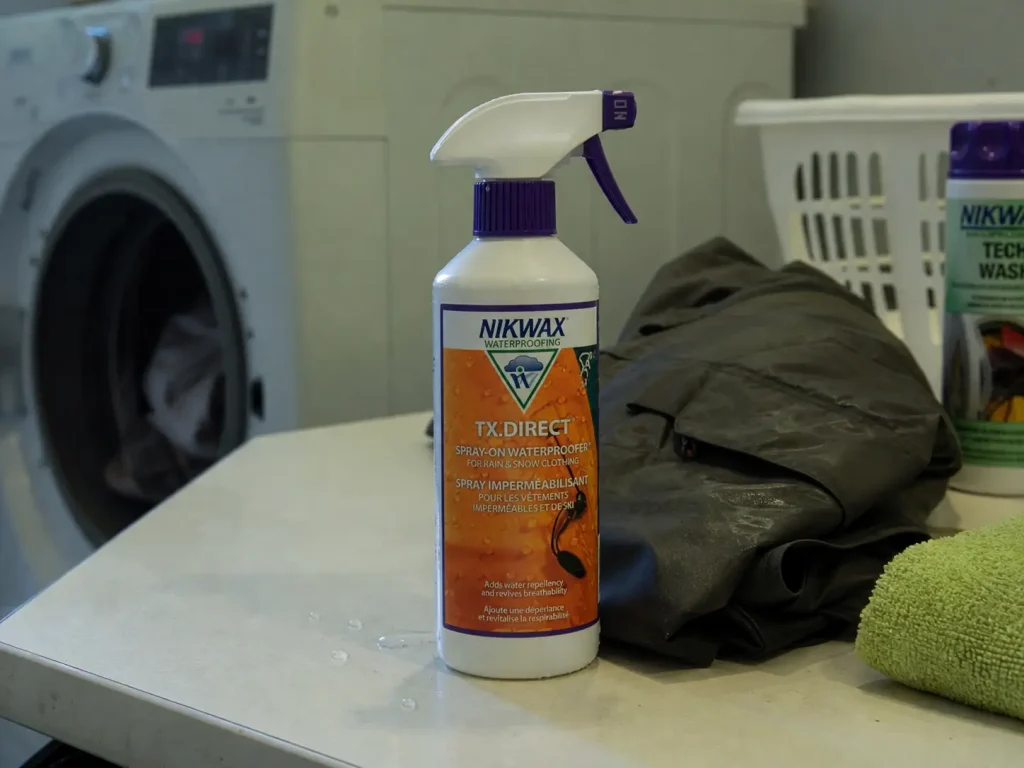 Waterproofing spray and technical wash set out beside a wading jacket before reproofing