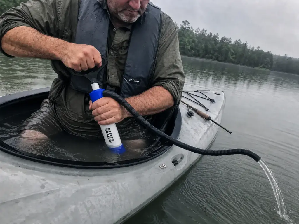 Angler pumping water from a swamped kayak cockpit with a manual bilge pump after reentry