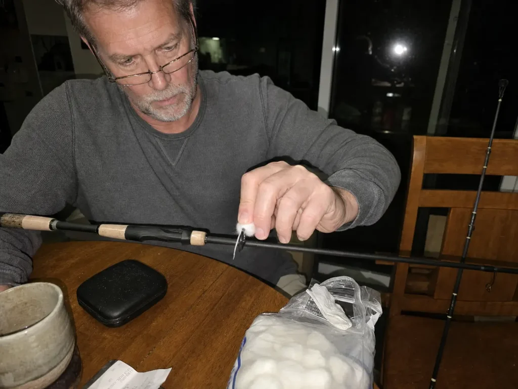 Running a cotton ball through a rod guide ring at the kitchen table to check for cracks before a trip