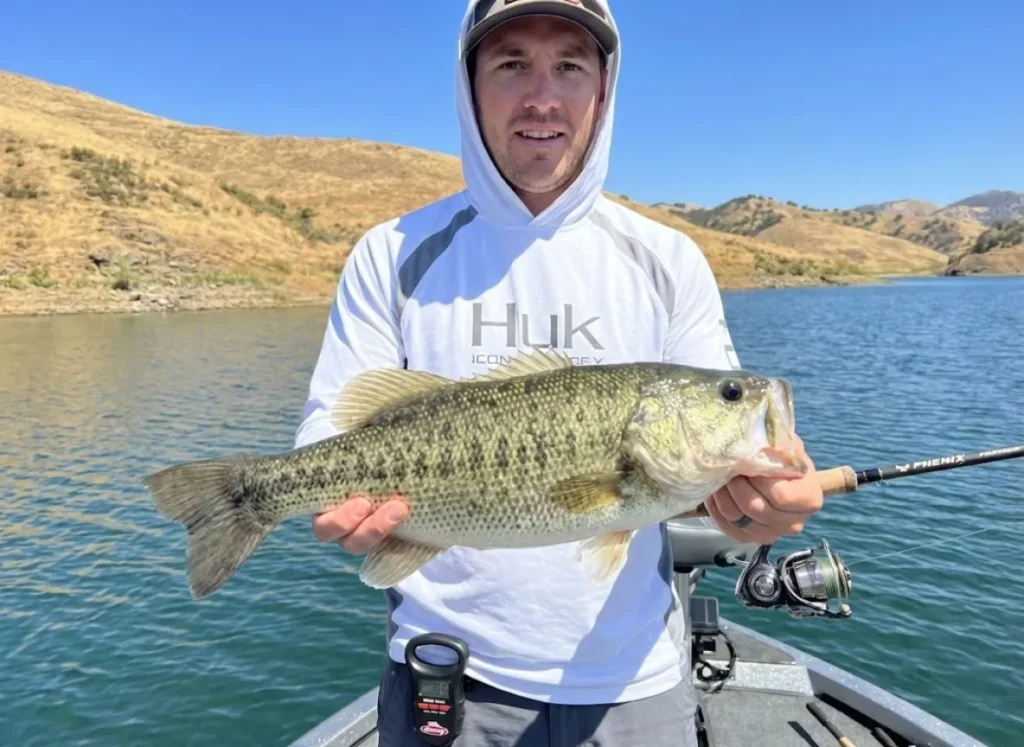 Angler holding trophy 7-pound Alabama bass on California reservoir with proper horizontal support