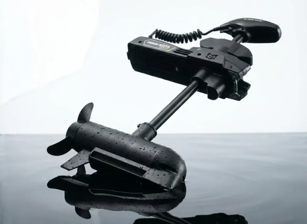 Macro photography detail of a high-end brushless trolling motor head, showing matte black textures and LED lights against dark water.