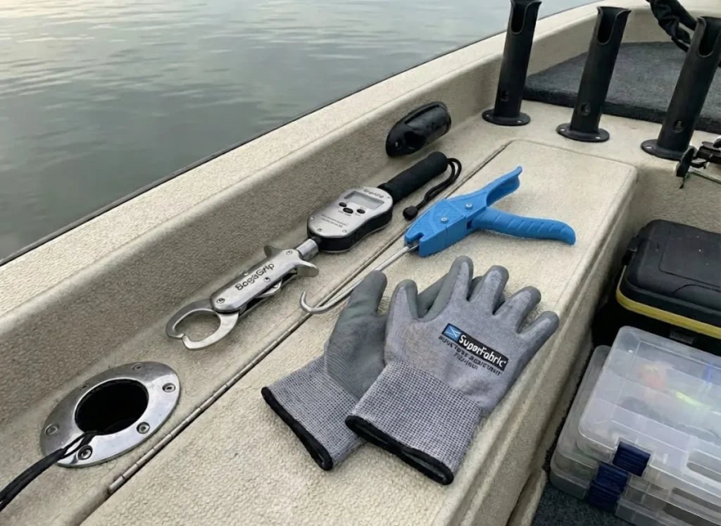 Professional catfish handling tools including lip gripper and dehooker on boat