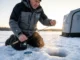 Cold Water Line Performance Tested: Mono vs Fluoro vs Braid Ice angler threading Seaguar IceX fluorocarbon through rod guides on frozen lake at sunrise