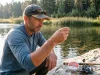 Why Fluorocarbon Isn’t as Invisible as You Think Angler holding clear fluorocarbon line up to gin-clear water to check its visibility