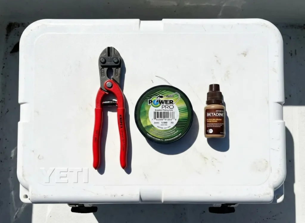 Knipex bolt cutters and PowerPro braided line arranged on a cooler as a field surgery kit.