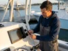 NMEA 2000 Network Guide: From Sonar to Trolling Motor Angler connecting NMEA 2000 network cable behind Garmin chartplotter on fishing boat