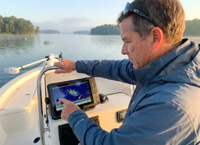 striped-bass-fish-finder-thermocline Angler reading fish finder for striped bass at thermocline depth in Chesapeake Bay