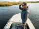 Tidal Currents & Predator Positioning: The Science Anglers Miss Angler reading tidal current seams at Georgia marsh creek mouth during golden hour