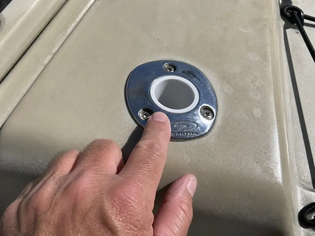 Close overhead view of a stainless flush mount rod holder recessed into a kayak deck