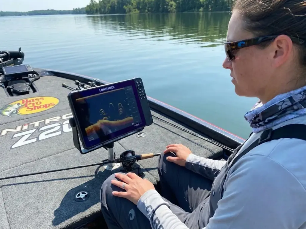 Angler watching fish finder showing fish refusing to bite during full moon lockjaw