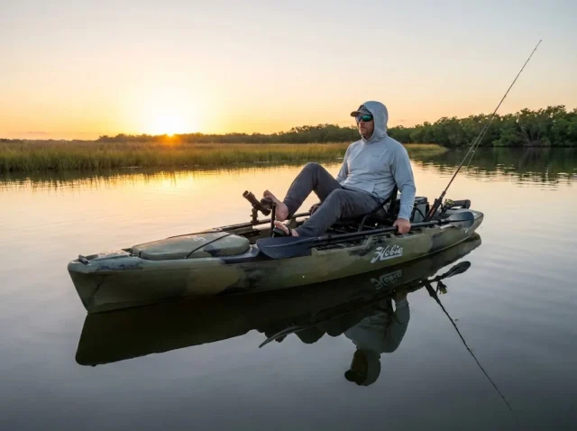 pedal-drive-kayak-fishing-dawn-flat Angler pedaling Hobie fishing kayak across shallow saltwater flat at dawn