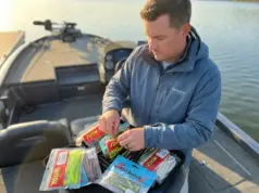 How to Store Soft Plastics So They Don’t Melt Together Angler organizing soft plastic lures in Bait BinderZ storage system on bass boat deck