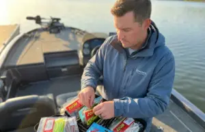 How to Store Soft Plastics So They Don’t Melt Together Angler organizing soft plastic lures in Bait BinderZ storage system on bass boat deck