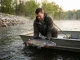 I Tracked Spring Catfish to Their Spawning Grounds Angler releasing a spring catfish near riprap spawning habitat on a misty river at dawn