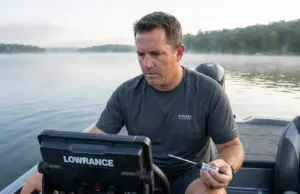 Surface Temps Lie When You Fish Deeper Water Angler checking water temperature at depth with Fish Hawk probe and Lowrance fish finder on summer lake