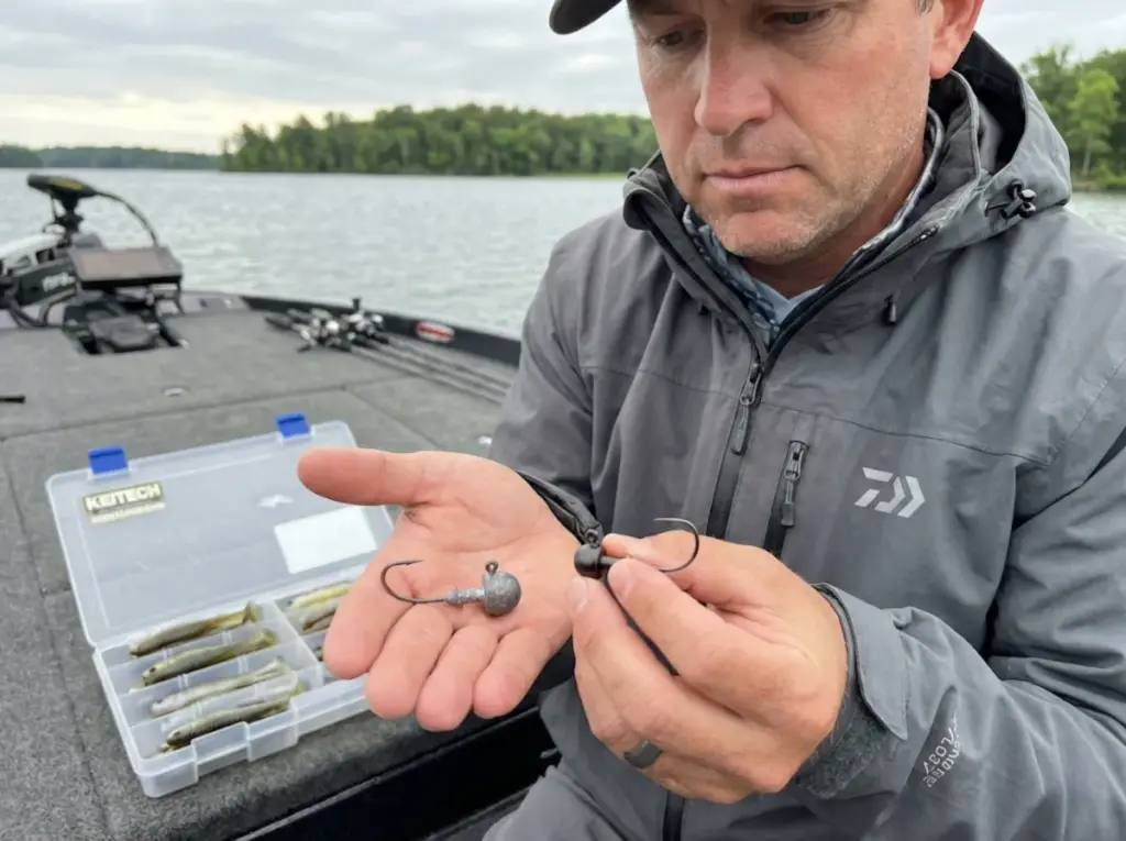 Angler comparing tungsten vs lead jig head sizes demonstrating density difference