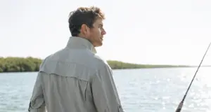 Best UPF Fishing Shirts That Survive the Wash Angler in a vented long-sleeve UPF fishing shirt on a skiff deck under high sun