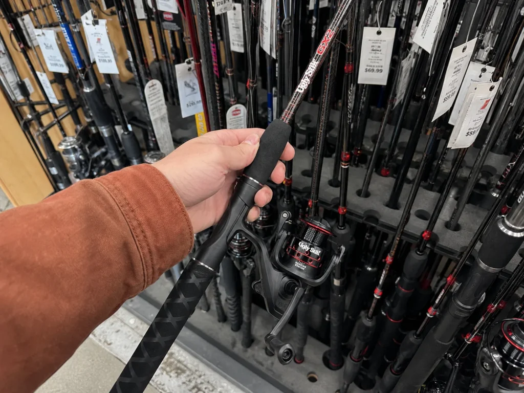 Budget two-piece Ugly Stik GX2 combo pulled from a crowded tackle shop rod rack