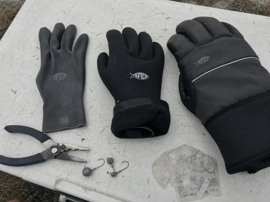 Three fishing gloves of different neoprene thickness laid out for comparison