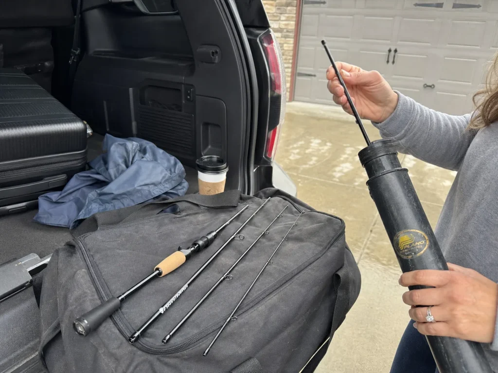KastKing Spartacus four-piece travel rod packing into a Plano rod tube beside a suitcase
