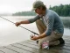 What Fishing Line for Beginners? Mono, Hands Down Beginner spooling monofilament fishing line onto a spinning reel at a quiet lake dock at dawn
