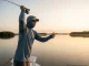 Best Fishing Sun Shirts UPF 50+ and Why Most Disappoint Angler in AFTCO UPF 50 fishing hoodie casting on saltwater flat at golden hour