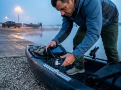 Best Kayak Fish Finder Mount Systems After 50+ Trips Angler securing Humminbird Helix 7 on RAM MOUNTS track ball system on fishing kayak at reservoir