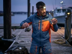 How to Detect a Cracked Rod Blank Before It Fails Angler inspecting graphite rod blank with flashlight to detect cracks before fishing