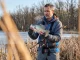 The Pre-Spawn Panfish Window Most Anglers Miss Angler holding large crappie in early spring south-facing bay with slipfloat rod, pre-spawn panfish