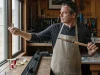 How to Build a Custom Fishing Rod Without Ruining It Rod builder inspecting a custom fishing rod grip and reel seat at his home workbench