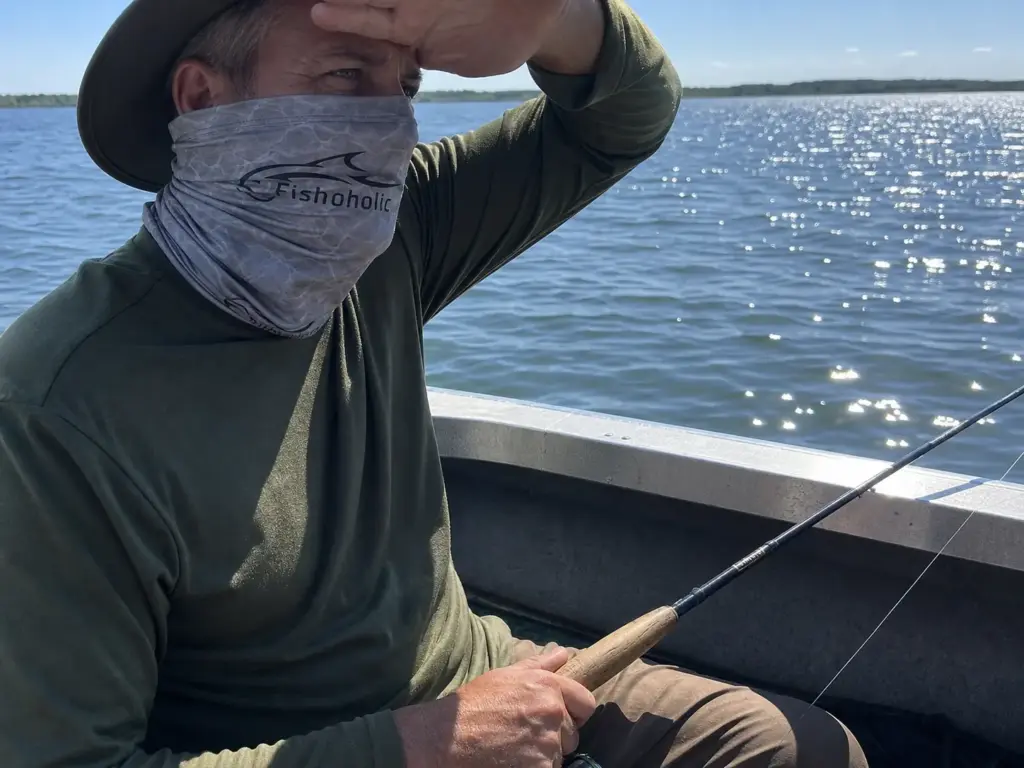 Fishing neck gaiter blocking reflected UV off open water during a midday session
