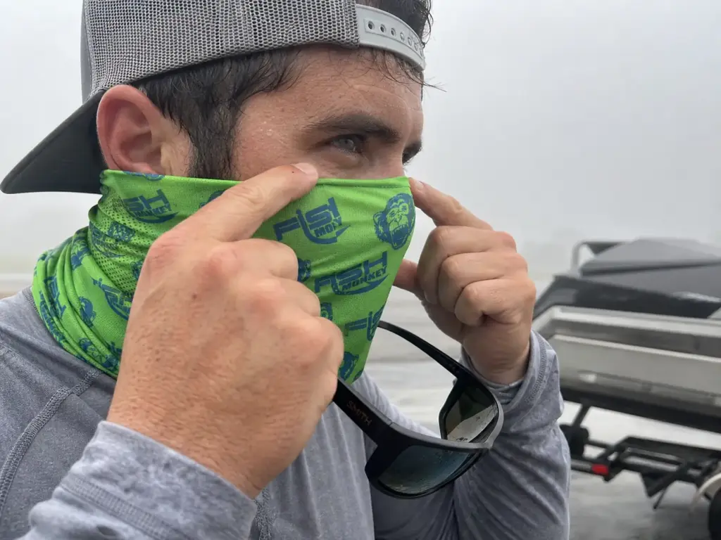 Seating a fishing neck gaiter over the nose bridge before sunglasses to stop fogging