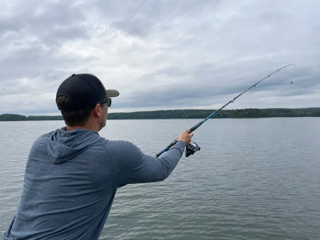 An angler casting a KastKing Compass telescoping rod across open water testing casting distance