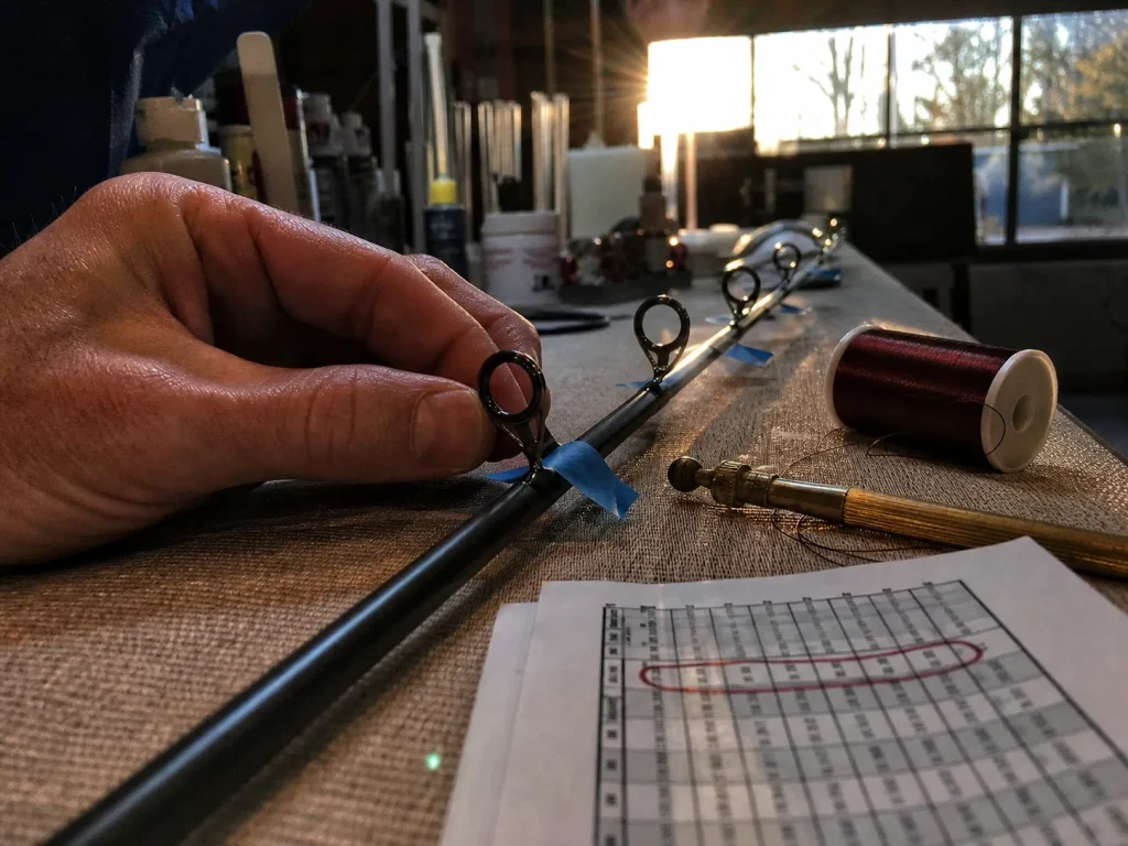 Line guides taped to a rod blank being sighted for alignment before the thread wrap goes on