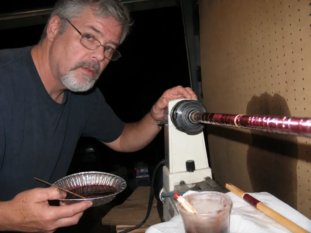 A wrapped fishing rod turning on a variable speed rod dryer while the epoxy finish coat cures