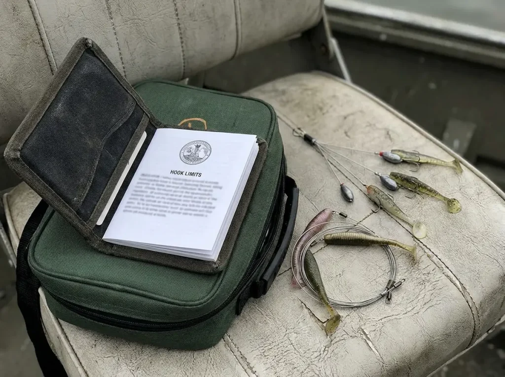 Open fishing regulation wallet showing hook limit rules beside an Alabama rig and tandem rig setup on a boat seat