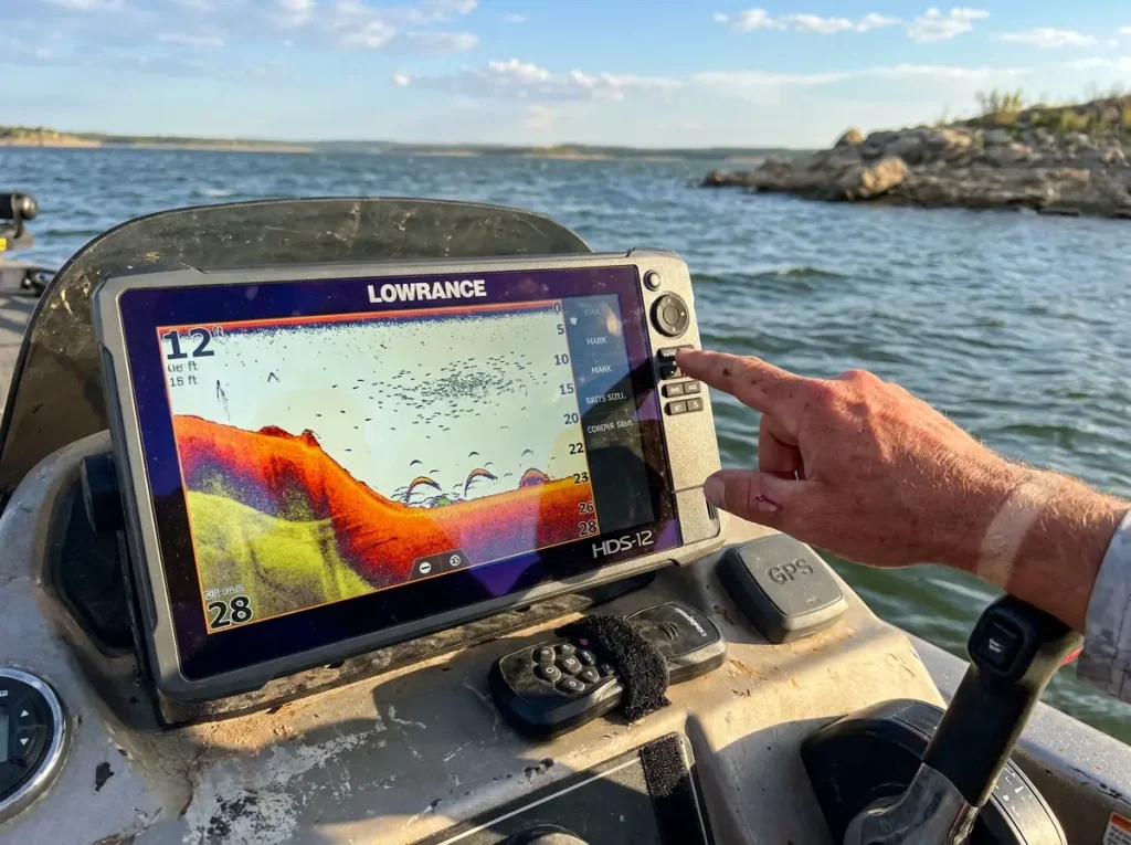 Fish finder screen showing bass holding on a deep ledge at 25 feet near channel swing