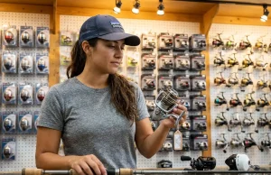 What Reel Should a Beginner Get? Not Always Spinning Beginner angler examining spinning reel at tackle shop counter