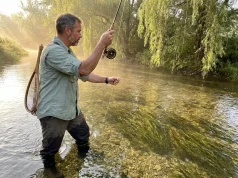 12 Best Trout Streams in Pennsylvania and Catskills Angler fly fishing a misty Pennsylvania limestone creek at dawn with wild trout rising