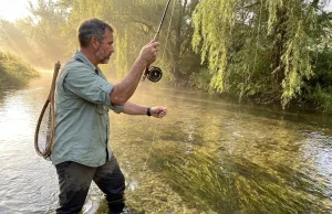 12 Best Trout Streams in Pennsylvania and Catskills Angler fly fishing a misty Pennsylvania limestone creek at dawn with wild trout rising