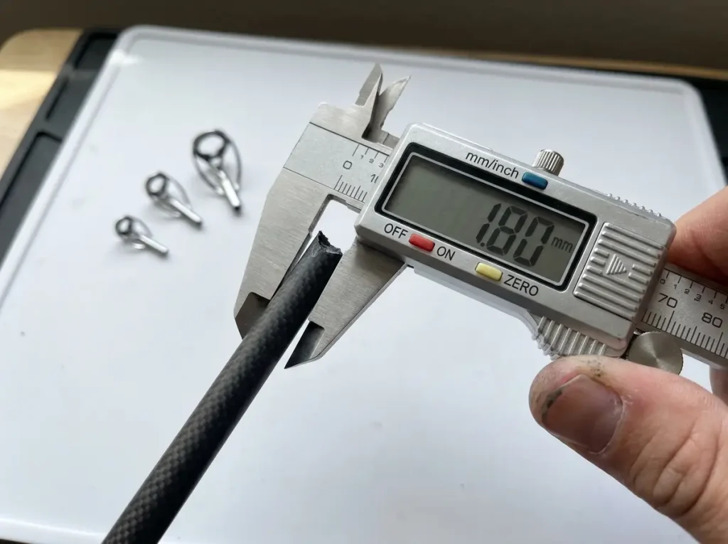 Digital caliper measuring the outside diameter of a fishing rod blank tip for sizing